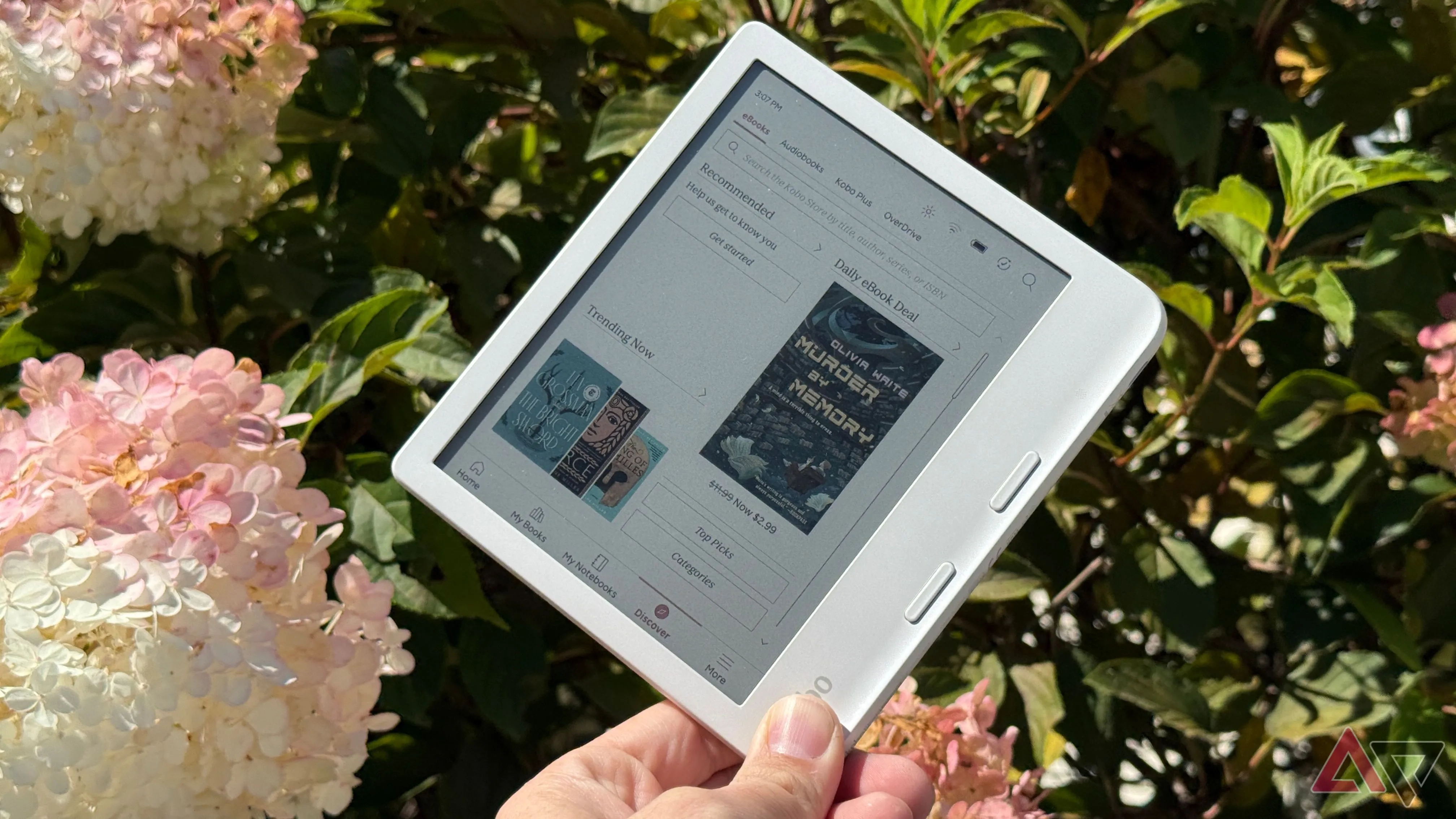 Kobo Libra Colour cầm trước nền hoa, minh họa e-reader là giải pháp thay thế smartphone