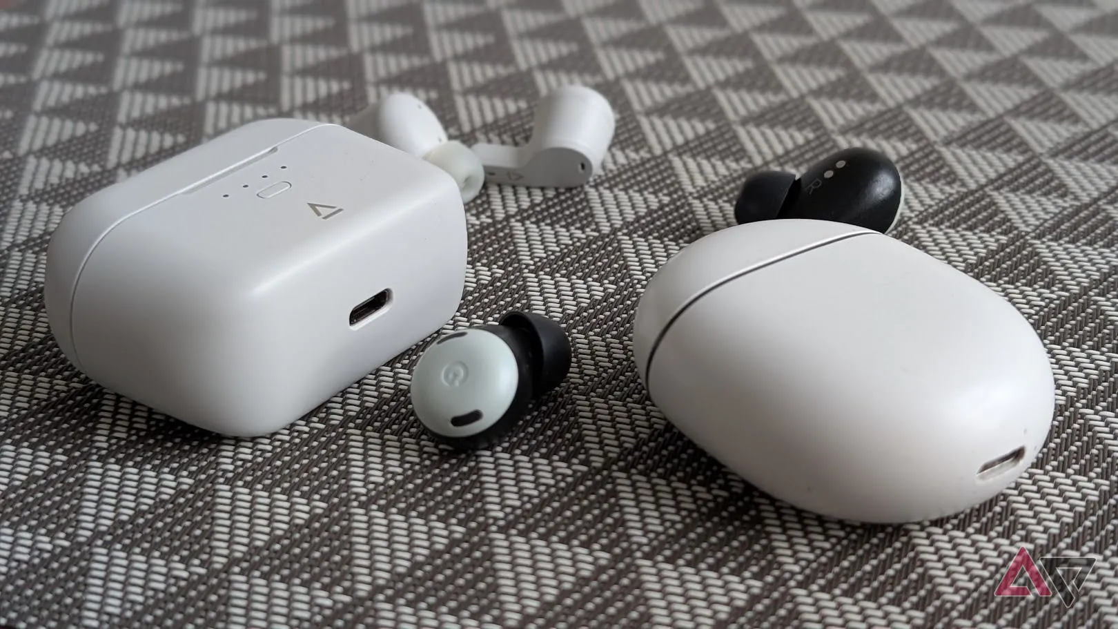 Pixel Buds Pro và Creative Zen Air SXFI đặt cạnh nhau trên nền đen trắng, so sánh thiết kế