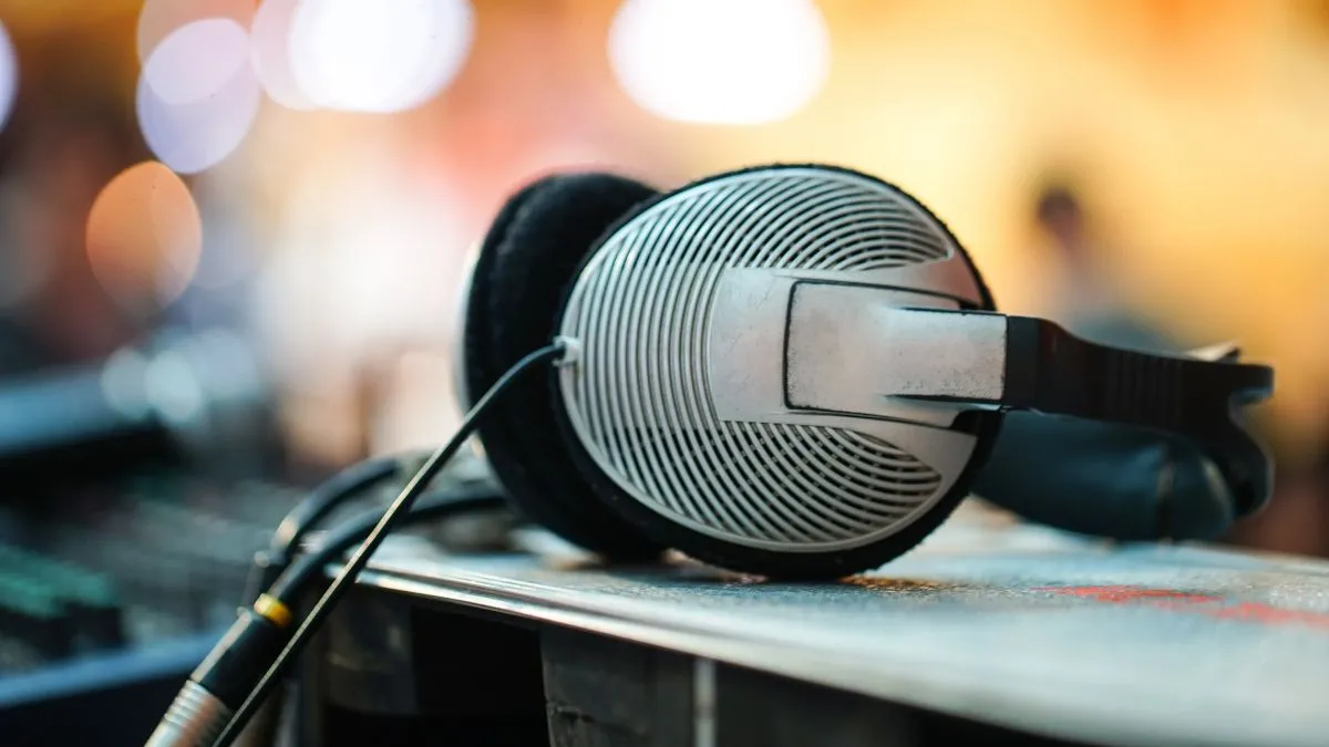 Tai nghe có dây đặt trên bàn với thiết bị âm thanh kỹ thuật, biểu trưng cho yêu cầu phần cứng để nghe lossless đúng chuẩn