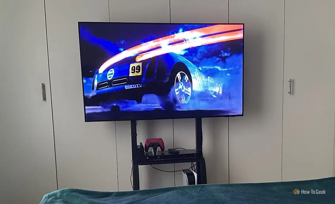 TV được gắn trên giá di động và đặt trong phòng ngủ, minh họa tính linh hoạt vị trí.